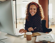 Woman smiling while sitting at desk in office