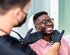 Dentist looking at patient's smile in treatment room