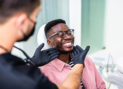 Dentist looking at patient's smile in treatment room