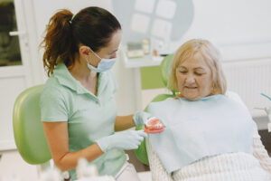 Older woman discussing denture care with dentist